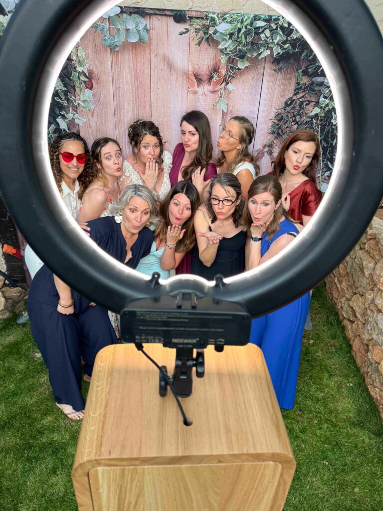 Groupe devant le photobooth en bois lors d'un mariage